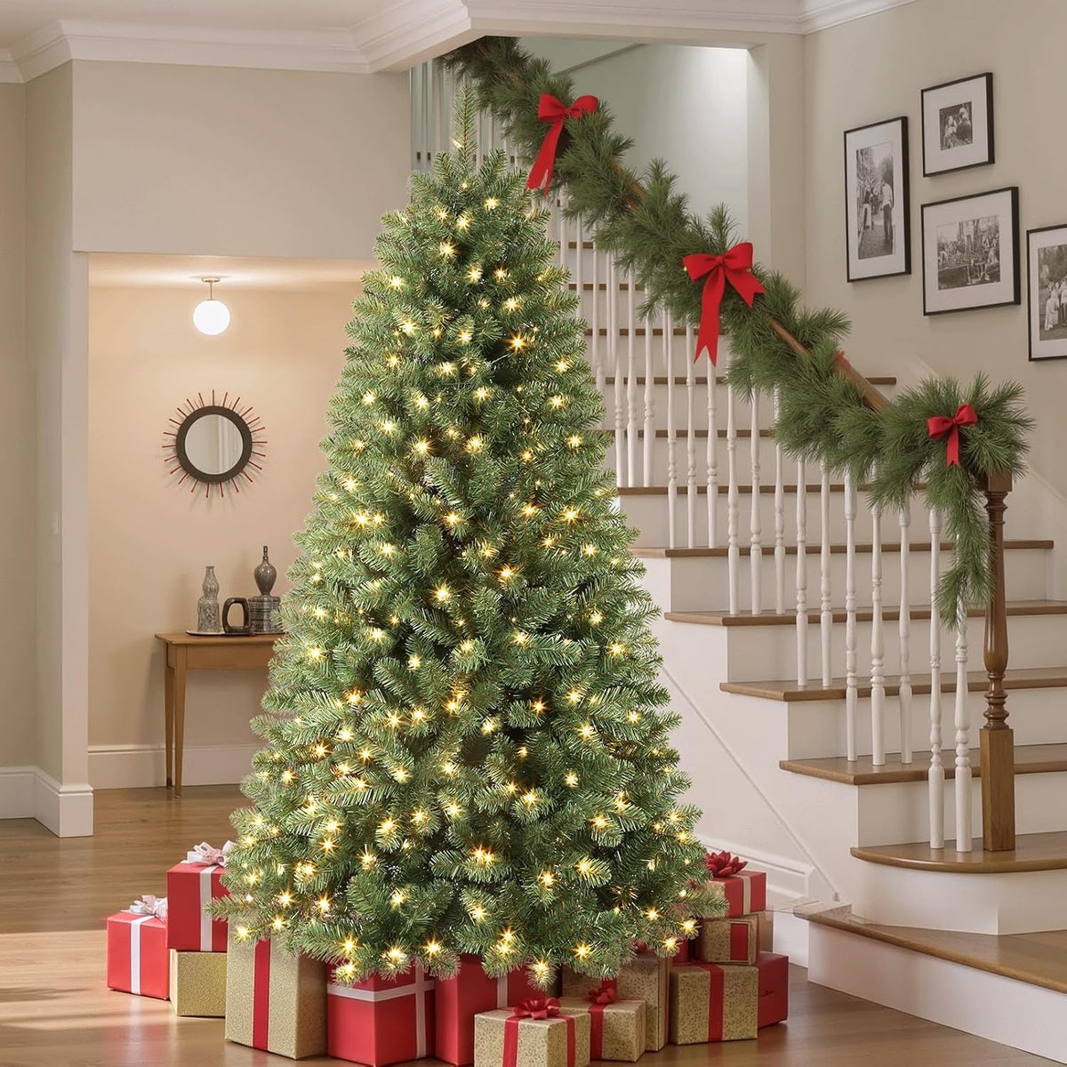 Green spruce Christmas tree in warm-white lighting mode beside a staircase.