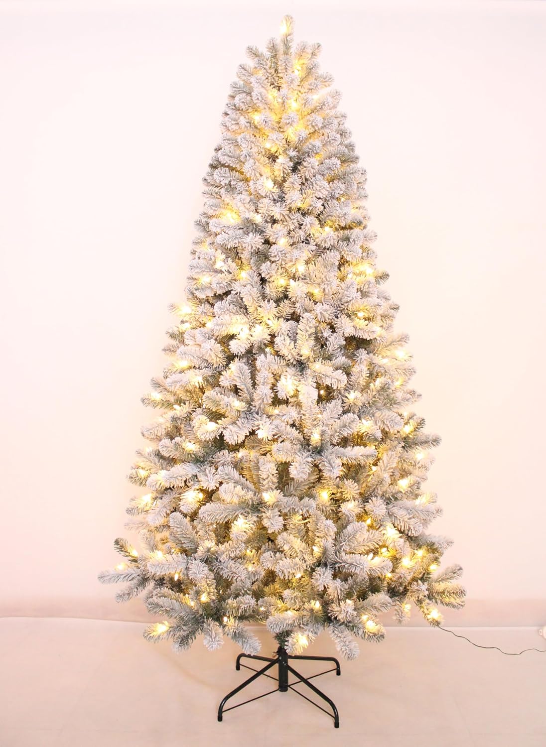 Flocked Christmas tree with a stand displayed against a light background.